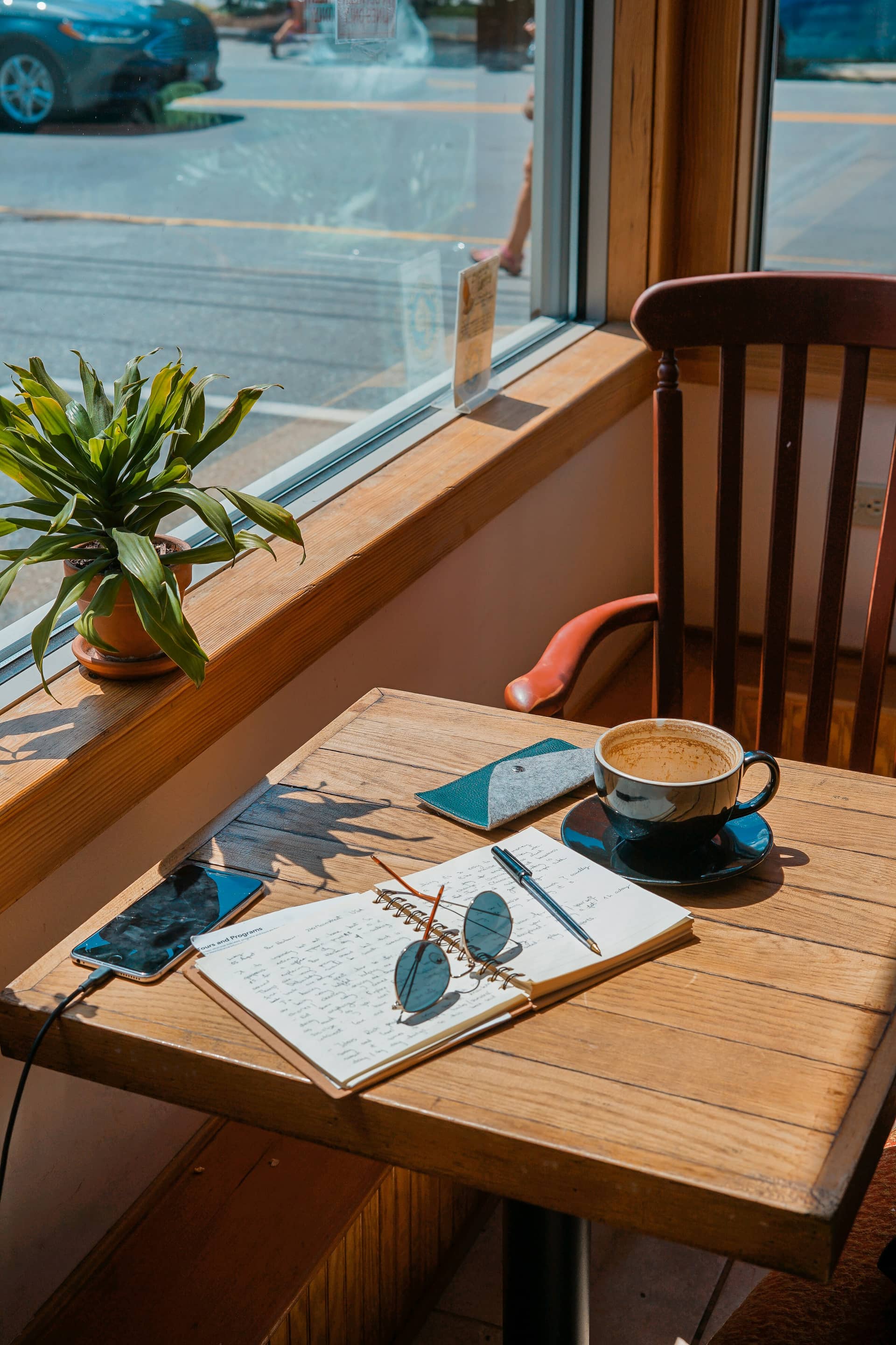 Person writing at a sunny desk